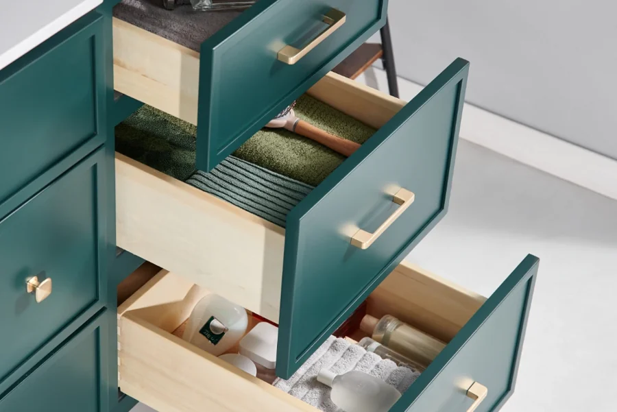 Green vanity drawers showing wood interiors and brass handles