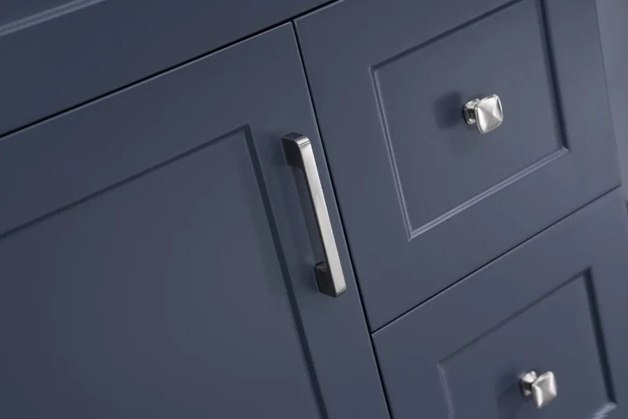 Close-up of a blue vanity cabinet finish and polished metal handles